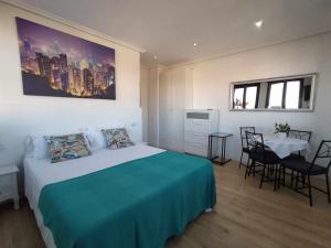 1 dormitorio con 1 cama y 1 mesa con sillas en Apartamento con vistas al puerto deportivo en Llanes