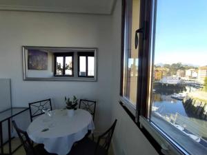 comedor con mesa y ventana grande en Apartamento con vistas al puerto deportivo en Llanes