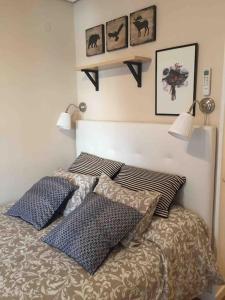 a bedroom with a bed with pillows on it at El nuevo corazón de Triana in Seville