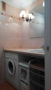 a bathroom with a sink and a washing machine at El nuevo corazón de Triana in Seville