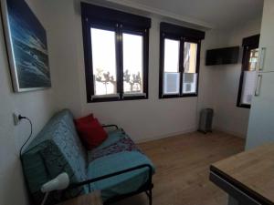 sala de estar con sofá y algunas ventanas en Apartamento con vistas al puerto deportivo en Llanes