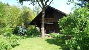 a log cabin with a tree in front of it at Ferienhaus Zur Einberger Schweiz in Rödental