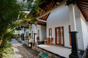 a house with white walls and a wooden ceiling at The Dagan Bungalow in Nusa Penida