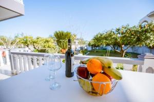 a bowl of fruit and a bottle of wine on a table at Casa Garden in Archangelos