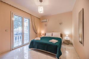 a bedroom with a green bed and a large window at Casa Garden in Archangelos