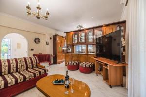 a living room with a couch and a flat screen tv at Casa Garden in Archangelos