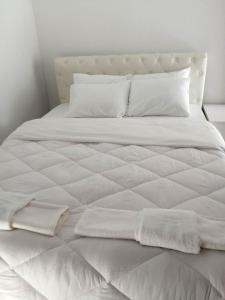 a white bed with white sheets and pillows on it at Cozy Rodas House 1 in Skála