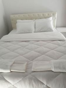 a large white bed with white sheets and pillows at Cozy Rodas House 1 in Skála
