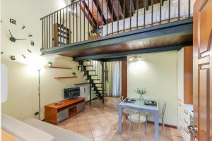 a living room with a table and a staircase at RHOme 24 - cozy attic at Rho Fiera in Rho