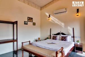 サワイ・マドプールにあるStayVista at Ranthambore Reverie - Near Ranthambore National Park with Lawn & Indoor-Outdoor Gamesのベッドルーム1室(ベンチ付)