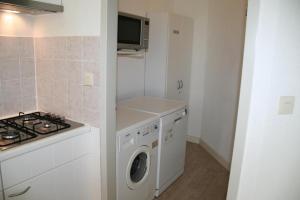 a kitchen with a washing machine and a stove at Liguster 51* in Nieuwvliet