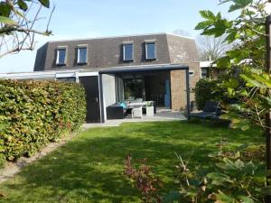 a house with a patio and a yard at Liguster 51* in Nieuwvliet