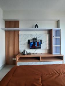 a bedroom with a desk with a tv on it at APARTMENT GRAND KAMALA LAGOON MY KIDS in Pulosirih