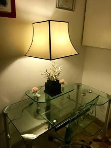 una lámpara sobre una mesa de cristal con una mesa de cristal sidx sidx sidx sidx sidx en Accogliente Trilocale in Gran Madre en Turín