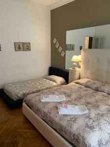 ein Hotelzimmer mit 2 Betten und einem Spiegel in der Unterkunft Accogliente Trilocale in Gran Madre in Turin