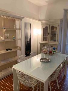una cucina con tavolo e sedie bianchi di Accogliente Trilocale in Gran Madre a Torino
