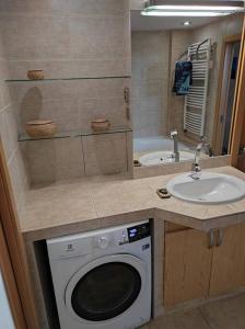 Un baño con lavadora y lavabo. en Very comfortable flat for the whole family, en Praga 42 fotos más