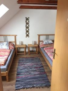 a attic room with two beds and a rug at Mezonetové apartmány Lea a Laura Donovaly in Donovaly