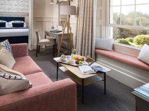 a living room with a couch and a table at Budock Vean Hotel in Falmouth