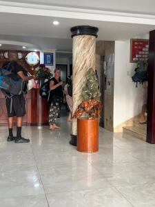 a group of people standing in a lobby with a column at Hà Tiên Hạnh Phúc Hotel in Ha Tien
