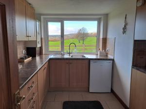 a kitchen with a sink and a window at Celtic Minor Cottage in Ystalyfera