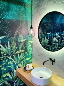 ein Badezimmer mit einem Waschbecken und einem großen Spiegel in der Unterkunft Casa Matko in Kostanjevica na Krasu