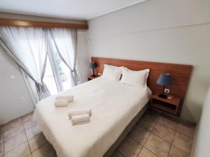 a bedroom with a large white bed with two chairs at Cosy Apartment with patio in Athens