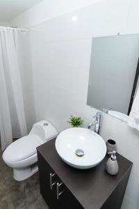 a bathroom with a white toilet and a sink at Comodo y amplio apartamento en Valledupar cerca al Parque la Leyenda in Valledupar