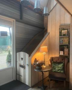 a room with a staircase with a table and a chair at de Hoeksesluis in Lekkerkerk