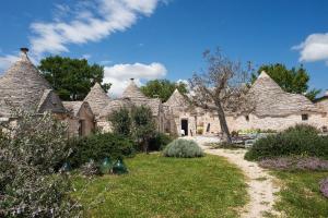 a group of stone houses with a grass yard at Le Dieci Porte in Alberobello