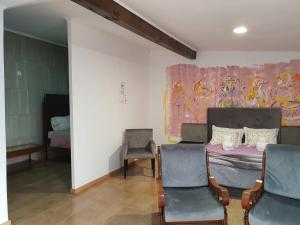 a bedroom with a bed and two chairs and a painting at Gojim Casa Rural in Armamar