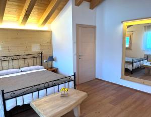 Schlafzimmer mit einem Bett, einem Tisch und einem Spiegel in der Unterkunft Chalet delle Dolomiti in Pieve di Cadore