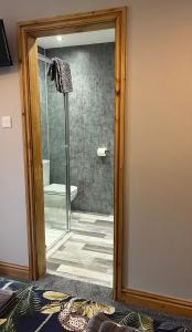 a bathroom with a glass door leading to a shower at The Manor Inn Pub and Steakhouse, Fridaythorpe, Driffield in York