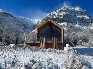 une maison dans la neige devant une montagne dans l'établissement Chalet Coste Belle, à La Fare-en-Champsaur