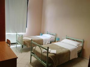 ein Krankenhauszimmer mit 2 Betten und einem Fenster in der Unterkunft Ostello 0571 in Castelfiorentino