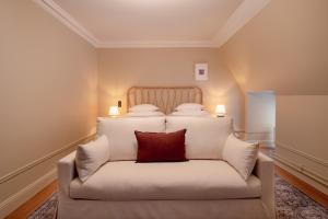 a bedroom with a white bed with a red pillow at Clas på Hörnet in Stockholm