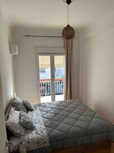 um quarto com uma cama em frente a uma janela em Elegant XL Apartment In Koukaki em Atenas