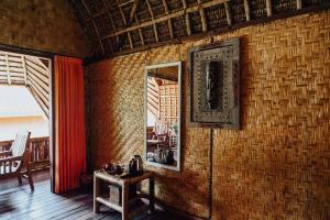 a room with a brick wall with a table and a mirror at Sasak Experience in Kuta Lombok
