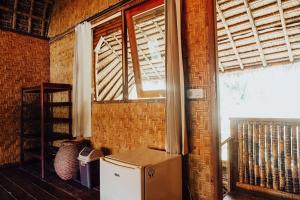 um quarto com um frigorífico e uma janela em Sasak Experience em Kuta