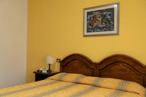 a bedroom with a bed and a picture on the wall at Albergo San Lorenzo in Grosseto