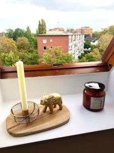 eine Figur eines Schweins und eine Kerze auf einer Fensterscheibe in der Unterkunft gemütliches Apartment Döhren in Hannover