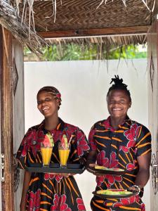 two men holding a tray of drinks at Mlango Paje House II in Paje