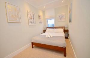 a small bedroom with a bed with white sheets at 2 Bedroom Flat London,Sleeps 6, Top Floor, Roof Terrace, Next to Brixton Underground Station in London