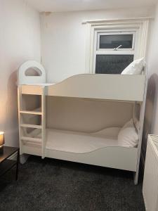 a white bunk bed in a room with a window at Holiday Plus - Holmfield Road in Blackpool