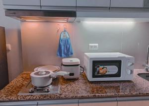 eine Küchentheke mit einem Mixer und einer Mikrowelle in der Unterkunft Casabay Suite Eastwood Staycation in Manila