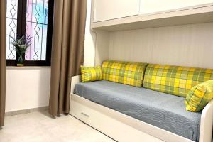 ein Sofa mit gelben Kissen in einem Zimmer mit Fenster in der Unterkunft La Coccinella in Graniti