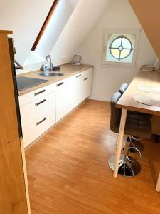 d'une cuisine avec un évier, une table et une fenêtre. dans l'établissement gemütliches Apartment Döhren, à Hanovre
