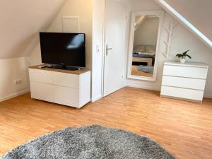 ein Wohnzimmer mit einem Flachbild-TV auf einer Kommode in der Unterkunft gemütliches Apartment Döhren in Hannover