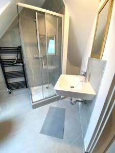 La salle de bains est pourvue d'un lavabo et d'une douche. dans l'établissement gemütliches Apartment Döhren, à Hanovre