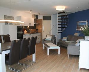eine Küche und ein Wohnzimmer mit Tisch und Stühlen in der Unterkunft Liguster 59* in Nieuwvliet